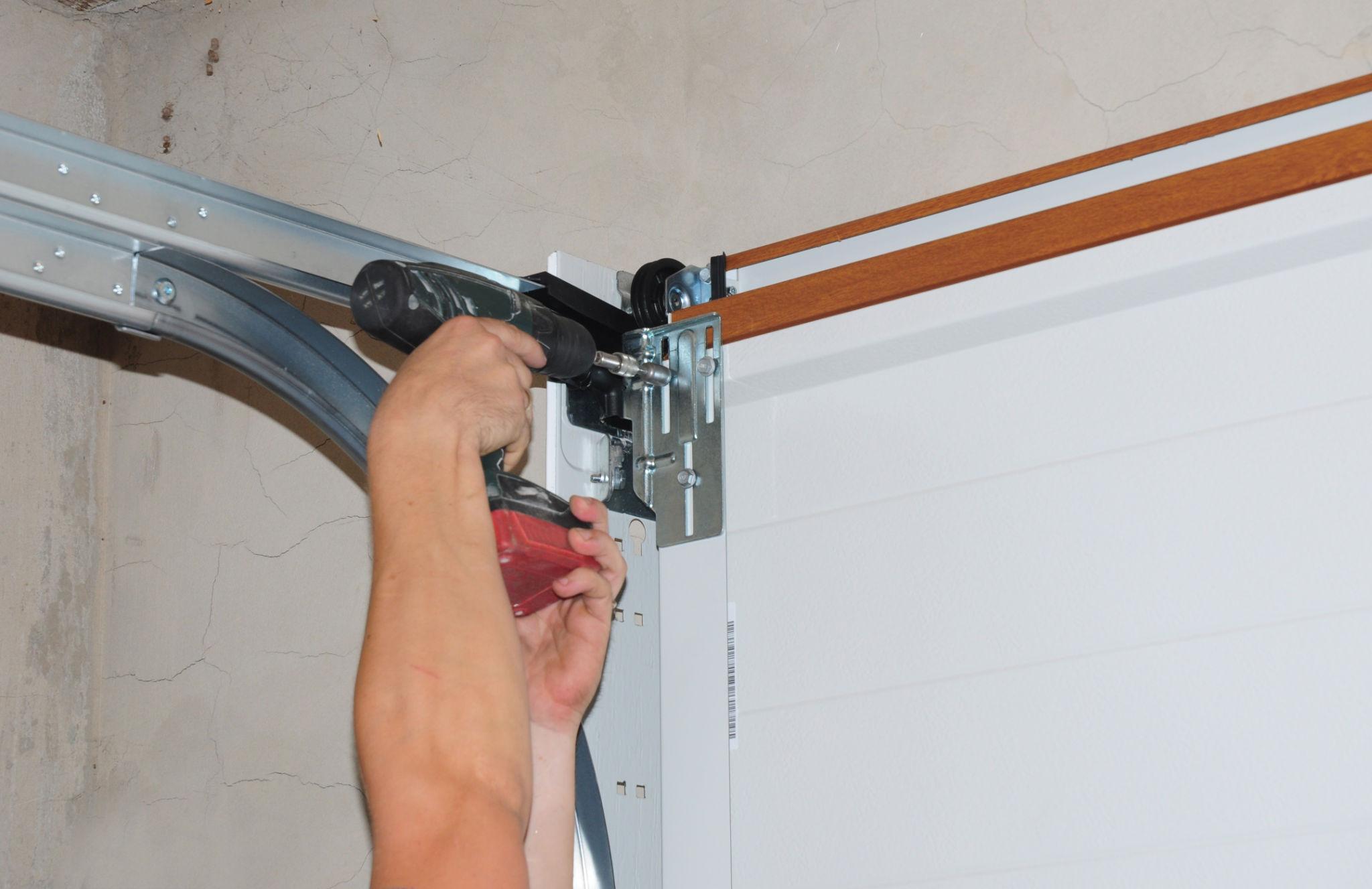 Garage door repair technician fixing a garage door